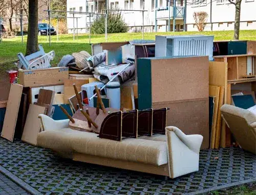 Ausgeräumte Altmöbel und eine Couch, zur Abholung bereitgestellt